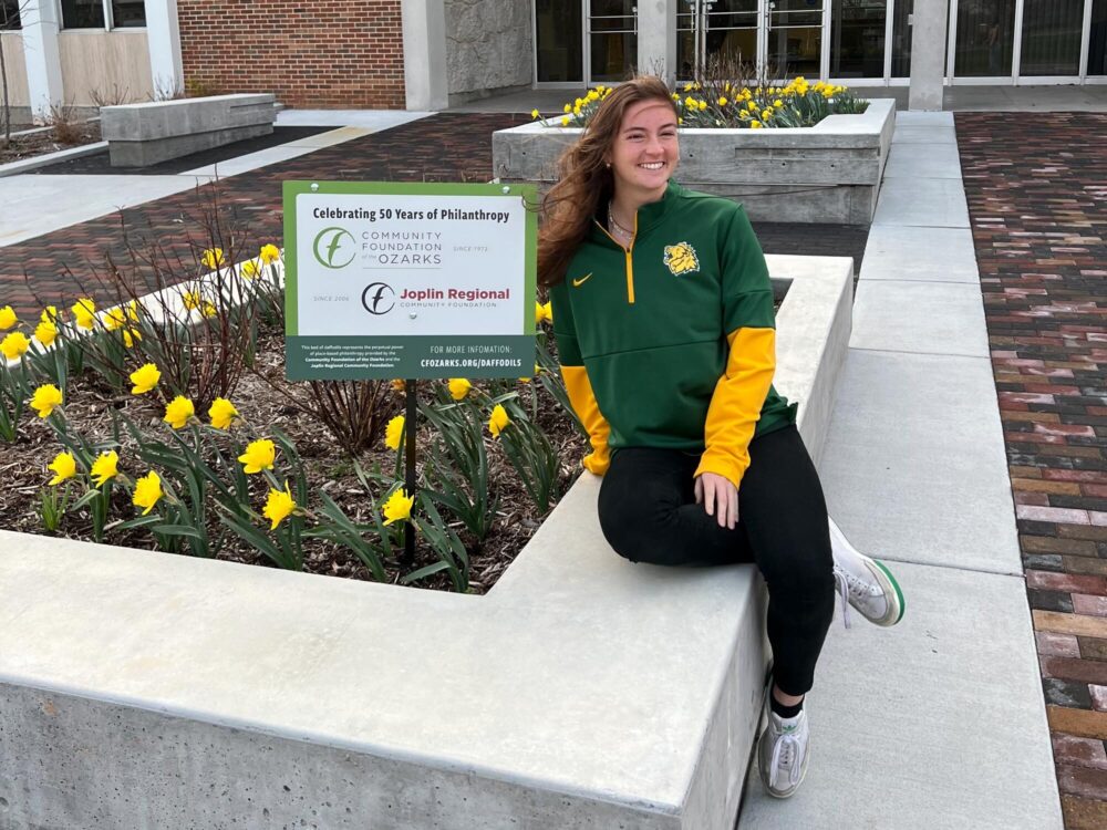 JRCF volunteer sits beside daffodils