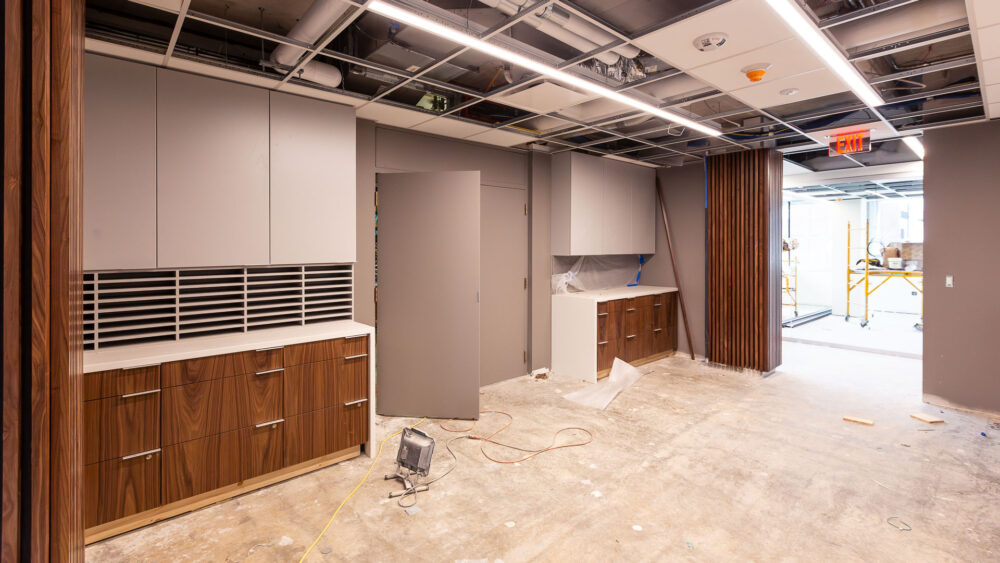 Image of the CFO's office renovation project showing a work room with gray walls and wood cabinets.