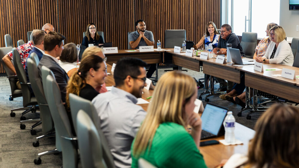A group of people are seated around a board room table. The CFO's Board of Directors met for the first time in its new headquarters on Aug. 20, 2025.