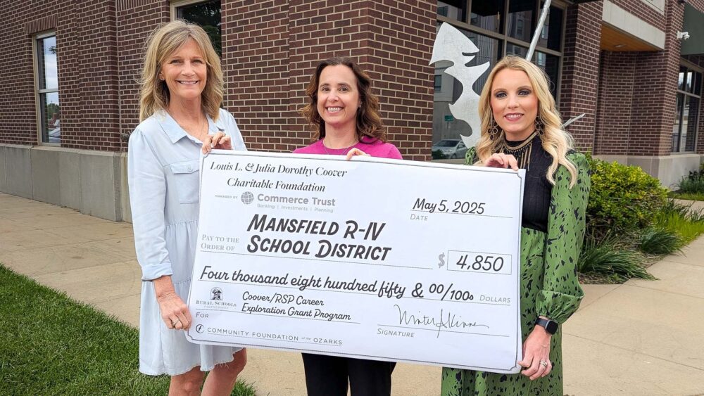 Three women -- Beth Hugs, Ashley Walden and Candice White -- hold an oversized check to the Mansfield R-IV School District for $4,850.
