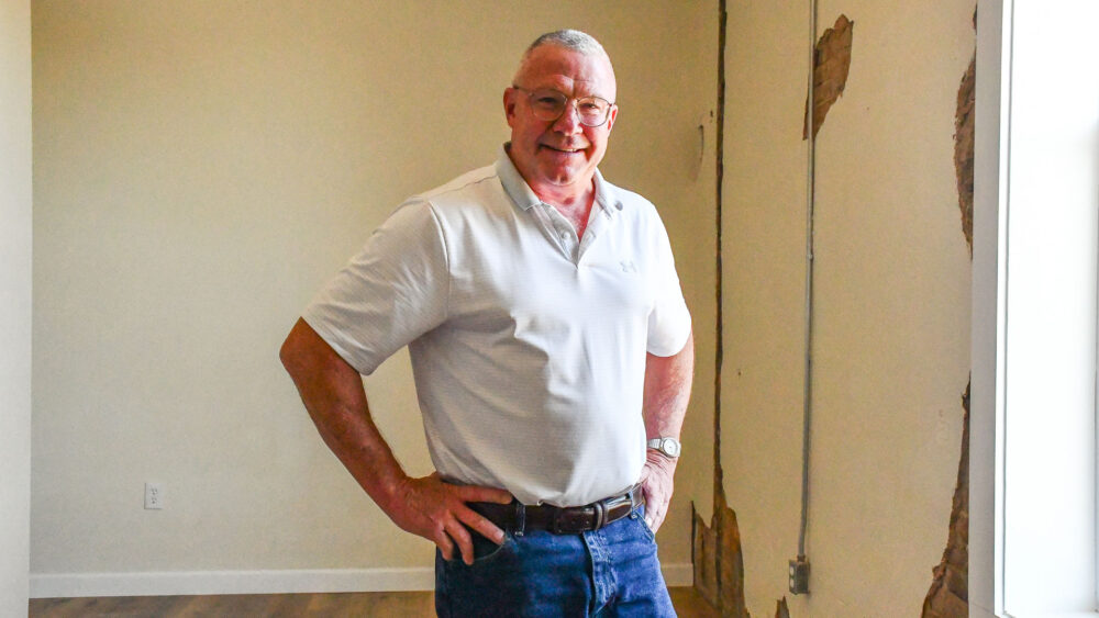 Photo of Dean Aye, a man standing inside a renovated apartment in Willow Springs.