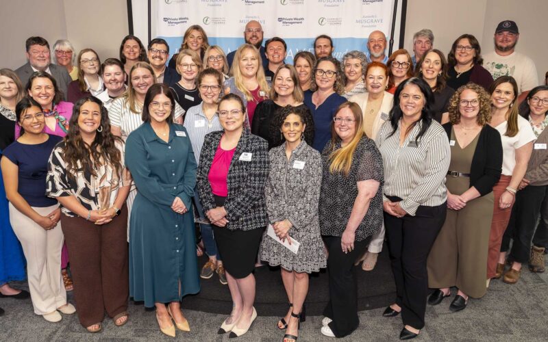 Dozens of people pose indoors in front of an event backdrop featuring logos for Jeannette L. Musgrave Foundation, Community Foundation of the Ozarks and US Bank Private Wealth Management.
