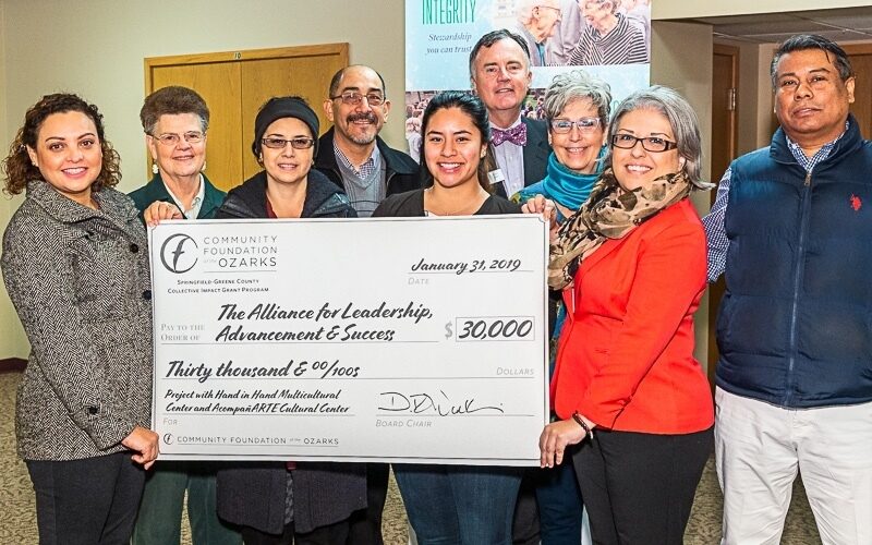 A group photo of individuals receiving a grant check