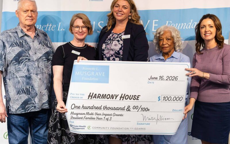 Five people hold a ceremonial $100,000 grant check for Harmony House from the Jeannette L. Musgrave Foundation during a grant presentation event.