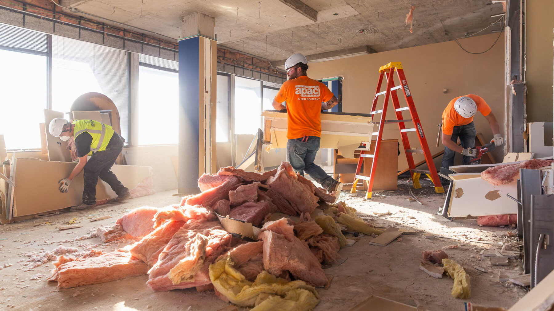 Three construction workers work to demolish existing walls at 300 South Jefferson in Springfield.