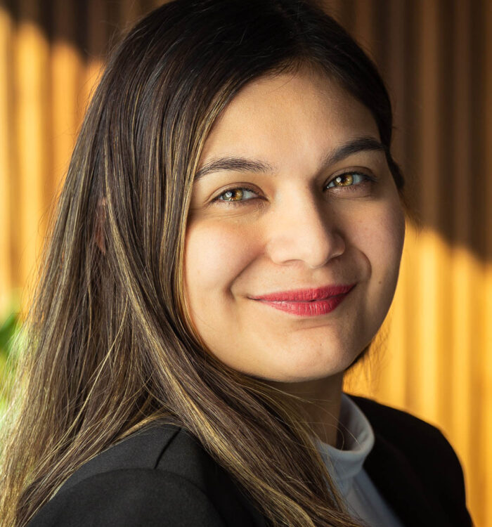 Portrait of Nabila Justiniano, a woman with dark brown hair wearing a white shirt and black jacket