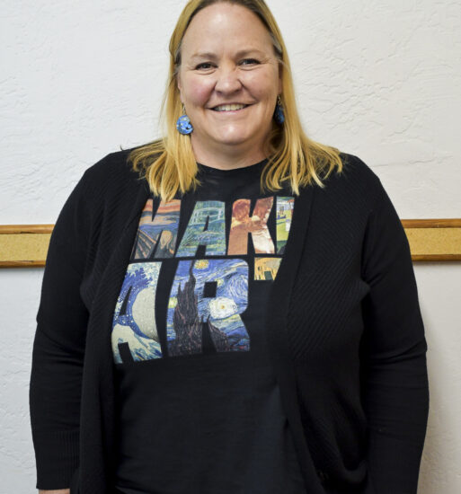 Portrait of Jennifer Jones, a woman wearing a black cardigan and a “Make Art” graphic T-shirt.