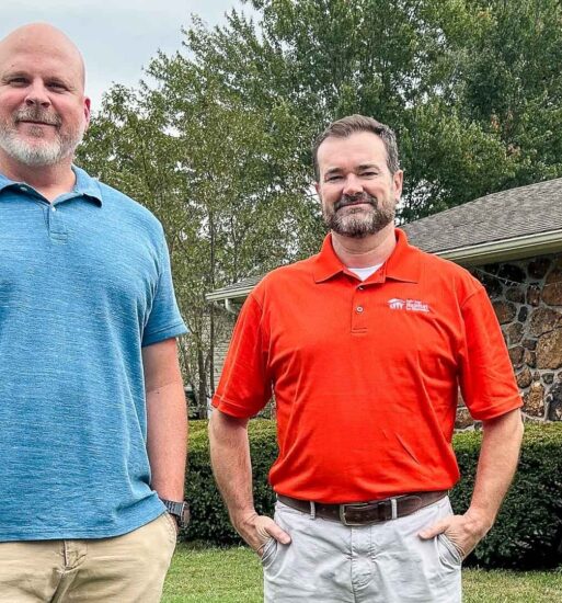Two men stand outside of a house in Joplin.