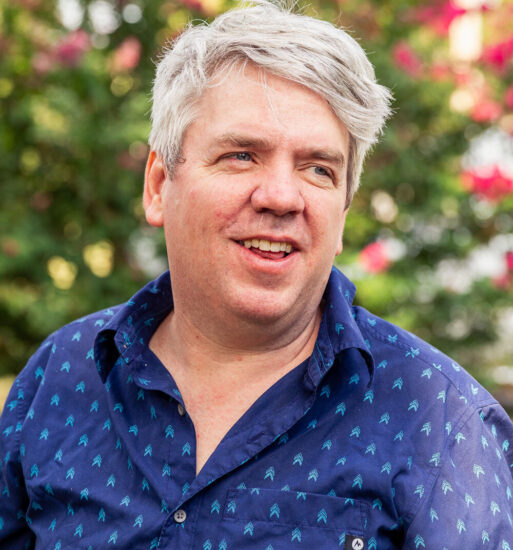 Portrait of Mike Stevens, a man in a dark blue shirt speaking outside.