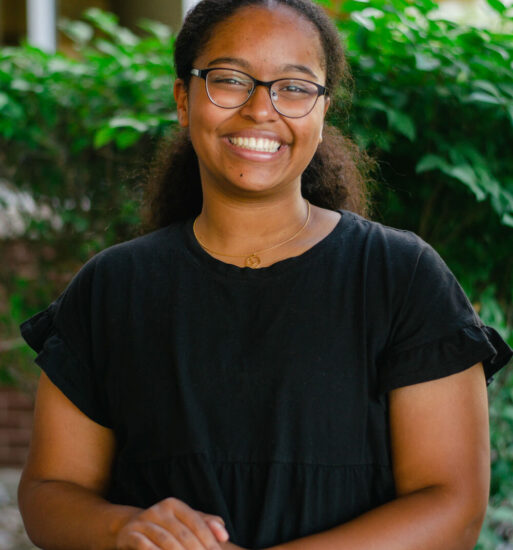 Portrait of Nicole McCain, a woman wearing glasses and a black shirt.